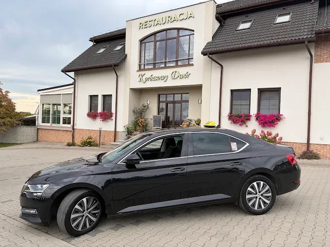 Czarna Škoda Superb Taxi Cieszyn przed restauracją