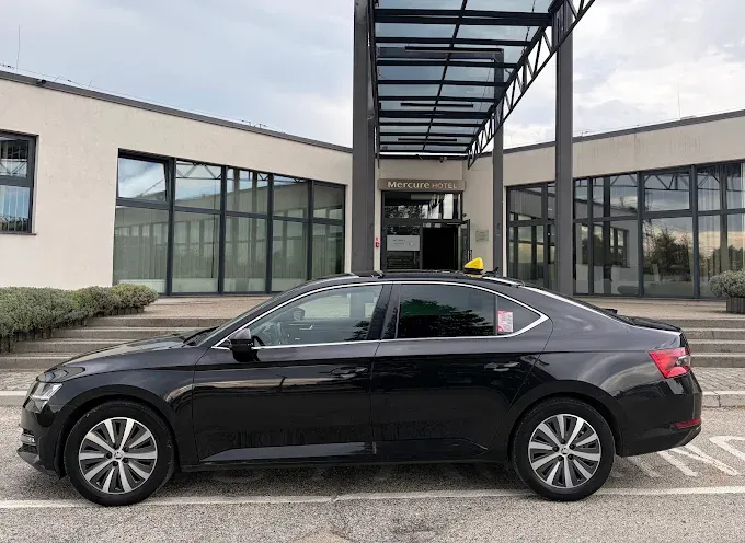 Czarna Škoda Superb Taxi Cieszyn przed hotelem